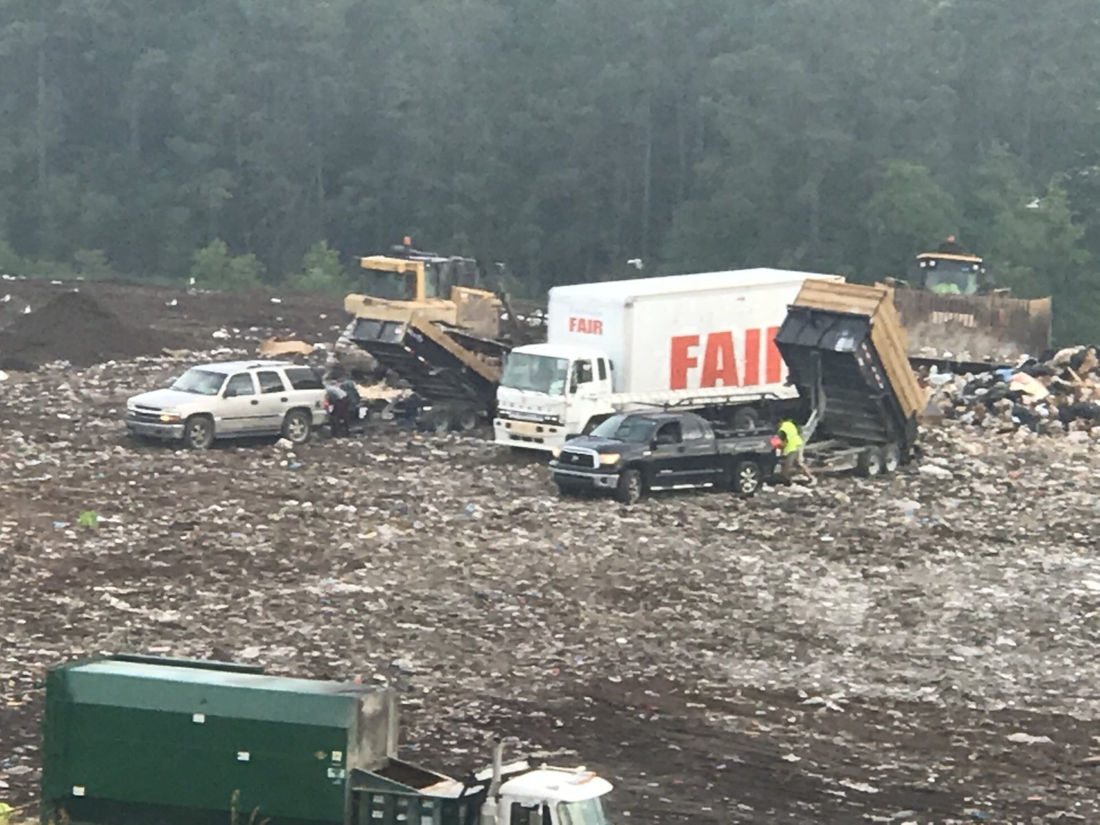 Trucks and equipment working among waste at a disposal site